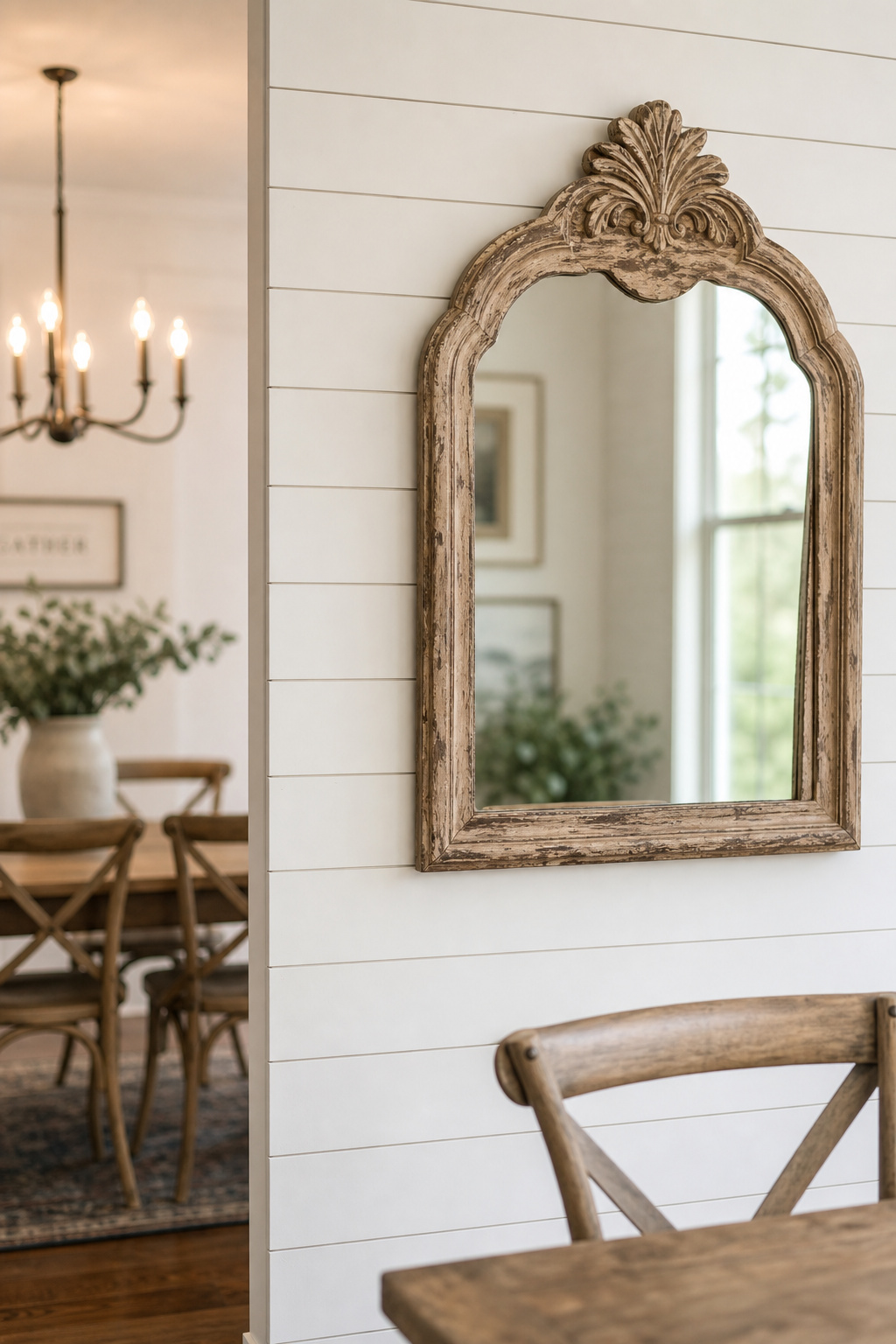 White horizontal shiplap accent wall in a farmhouse dining room with a distressed-wood framed mirror at centre and the shadow lines of the board reveals visible in daylight