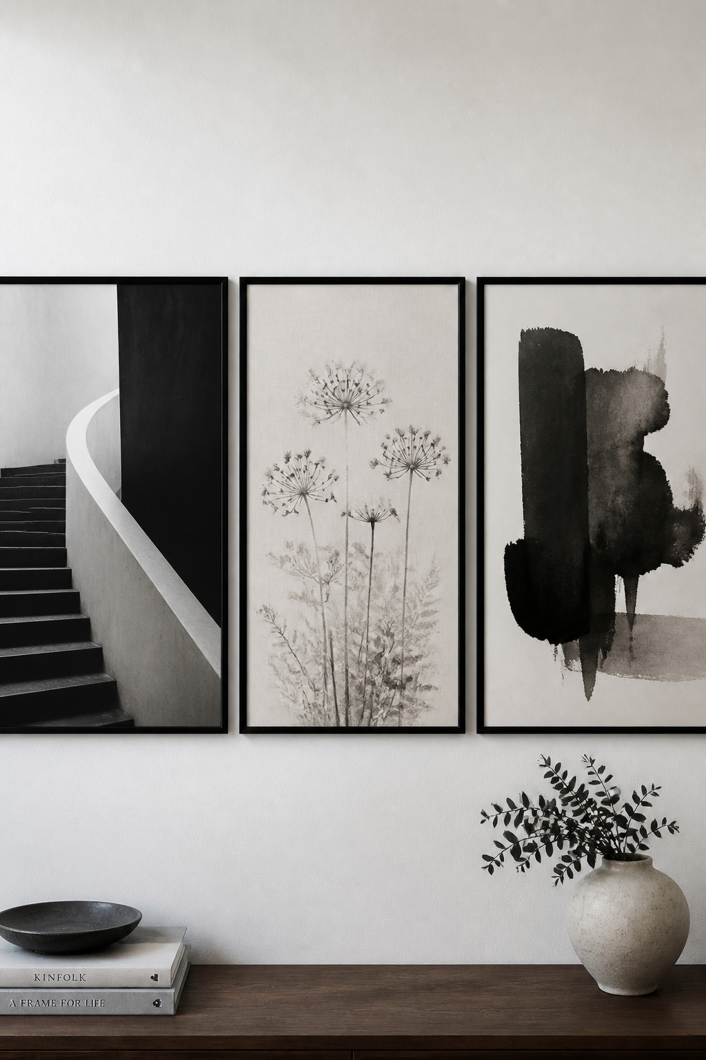 Three black and white prints of different subjects — architecture, botanical, abstract — unified by monochrome palette and identical black frames