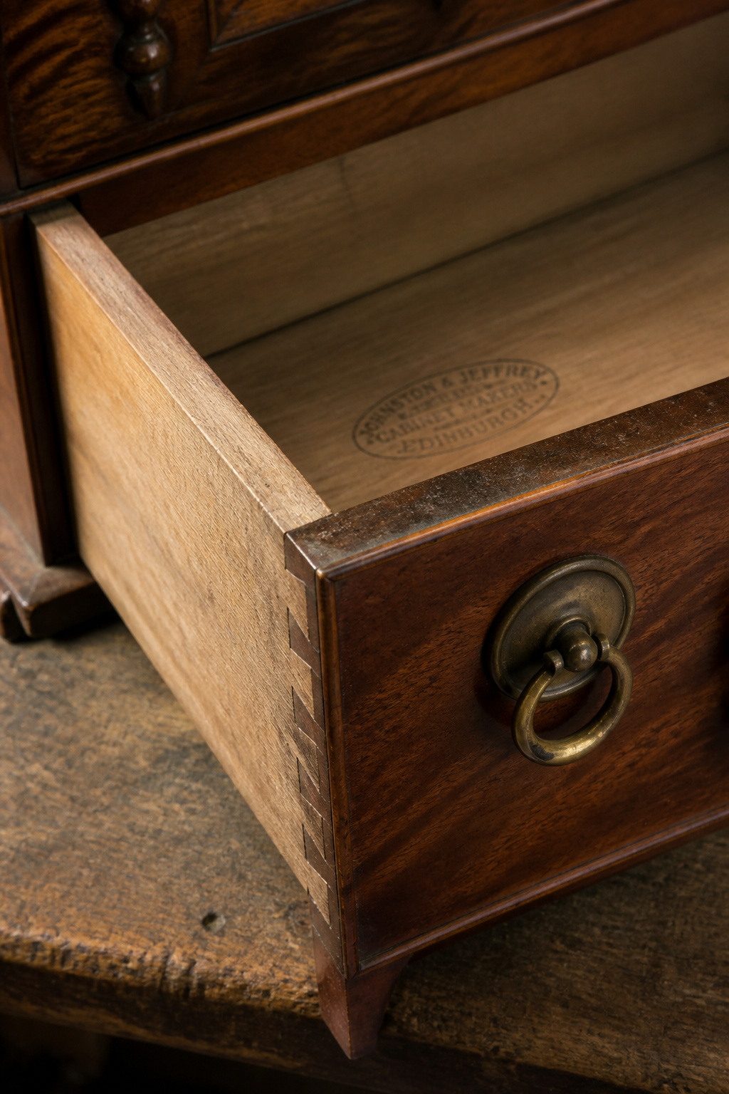 Victorian mahogany dresser drawer revealing hand-cut dovetail joints and a maker's stamp on the bottom — signs a piece may be too good to paint