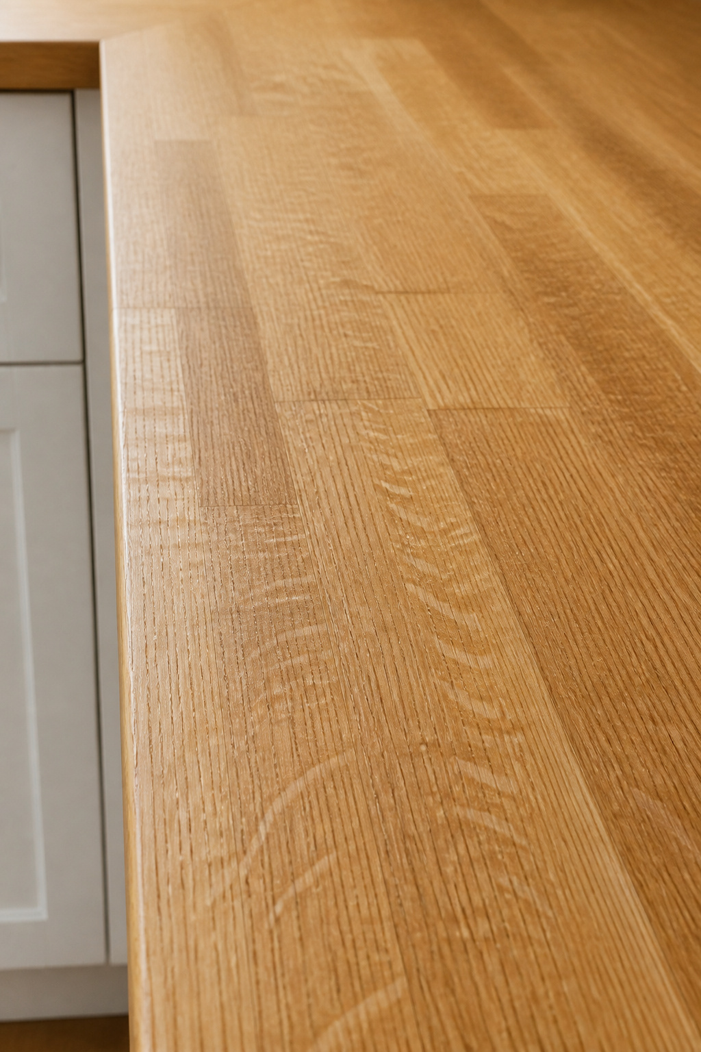 White oak edge-grain butcher block close-up showing the distinctive medullary ray silver fleck pattern and warm honey-amber tone