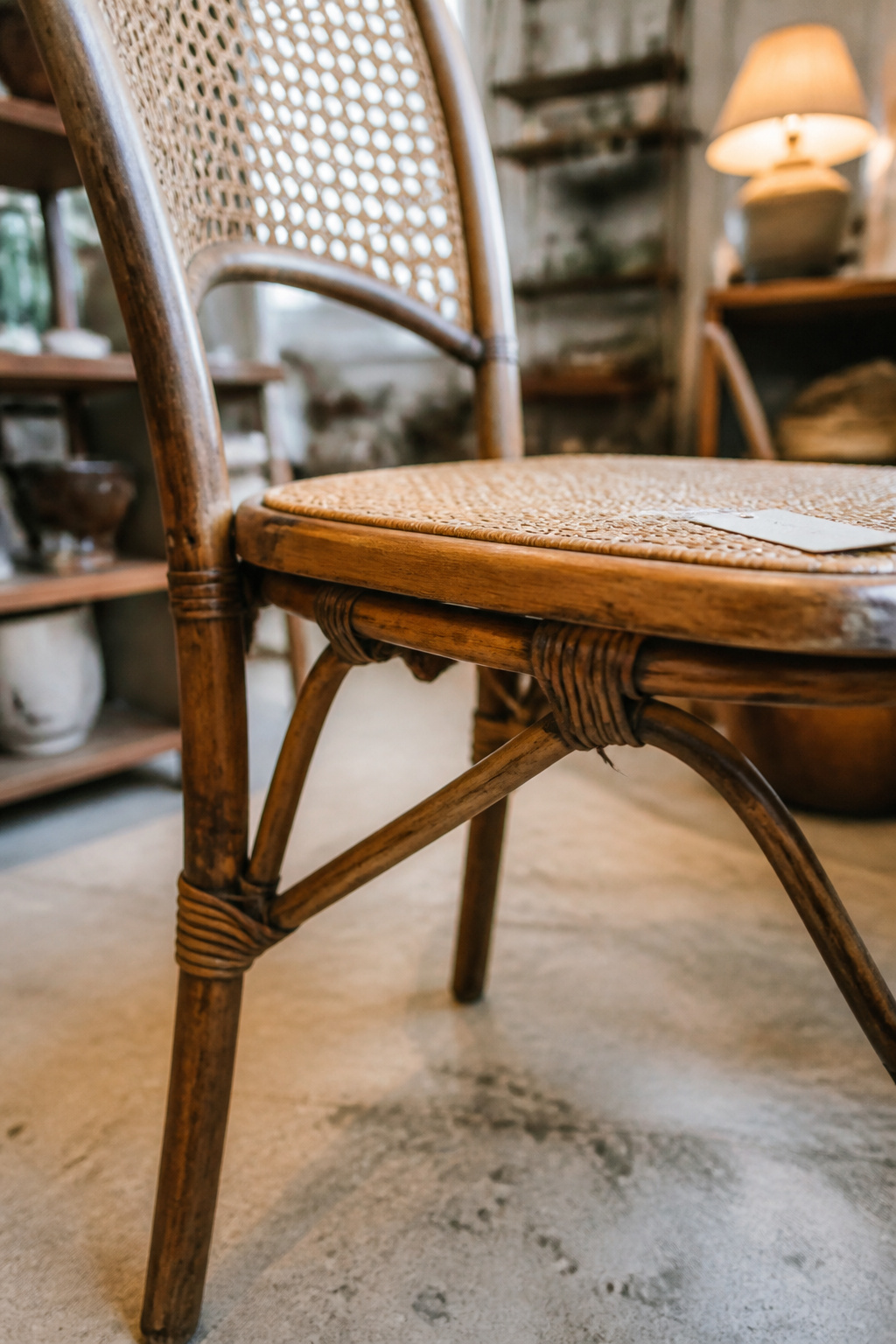 Vintage rattan dining chair with visible leg joinery being inspected before a secondhand purchase