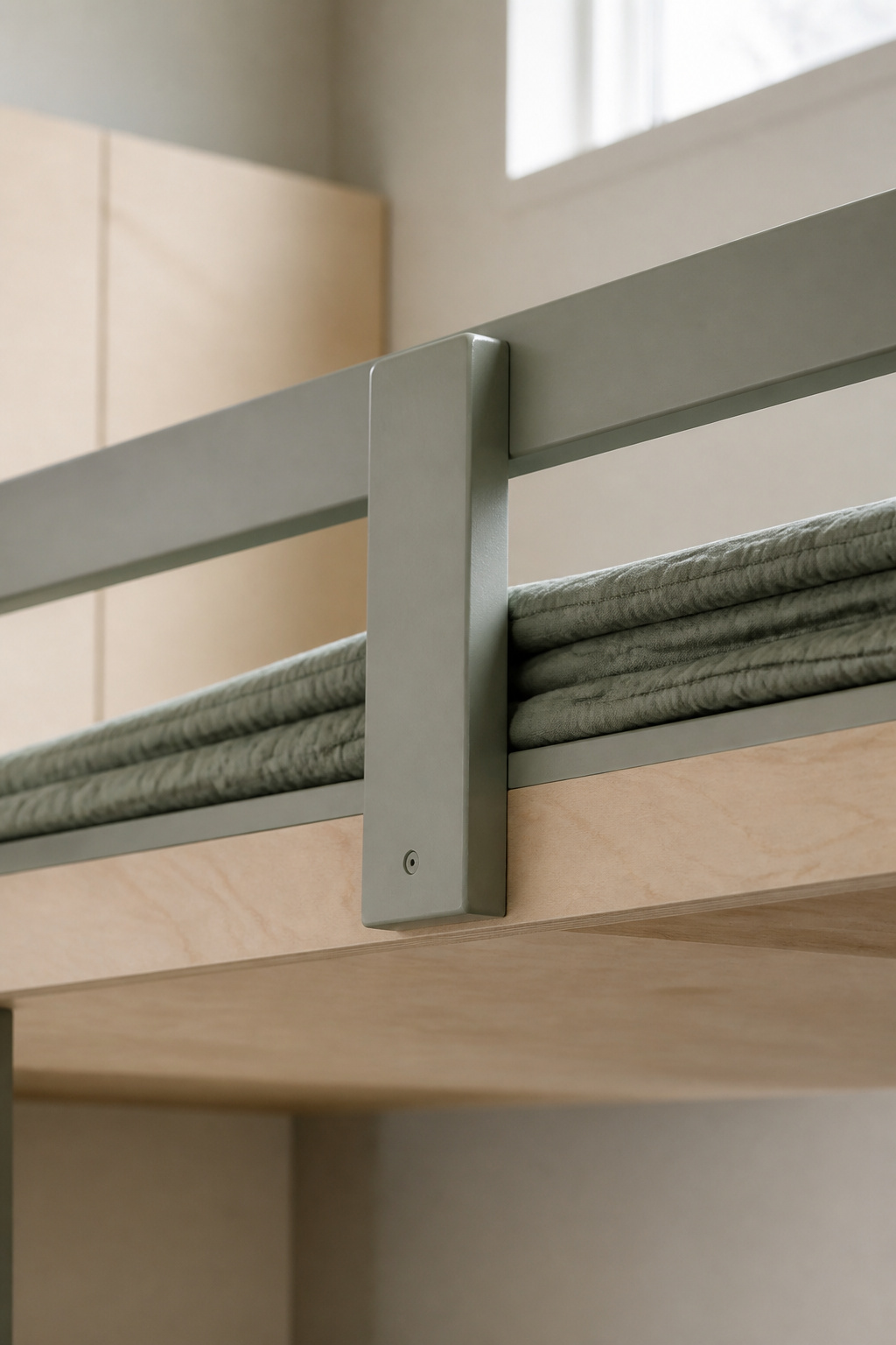 Close view of a painted wood guardrail attached to a built-in bunk bed platform edge above a made-up mattress