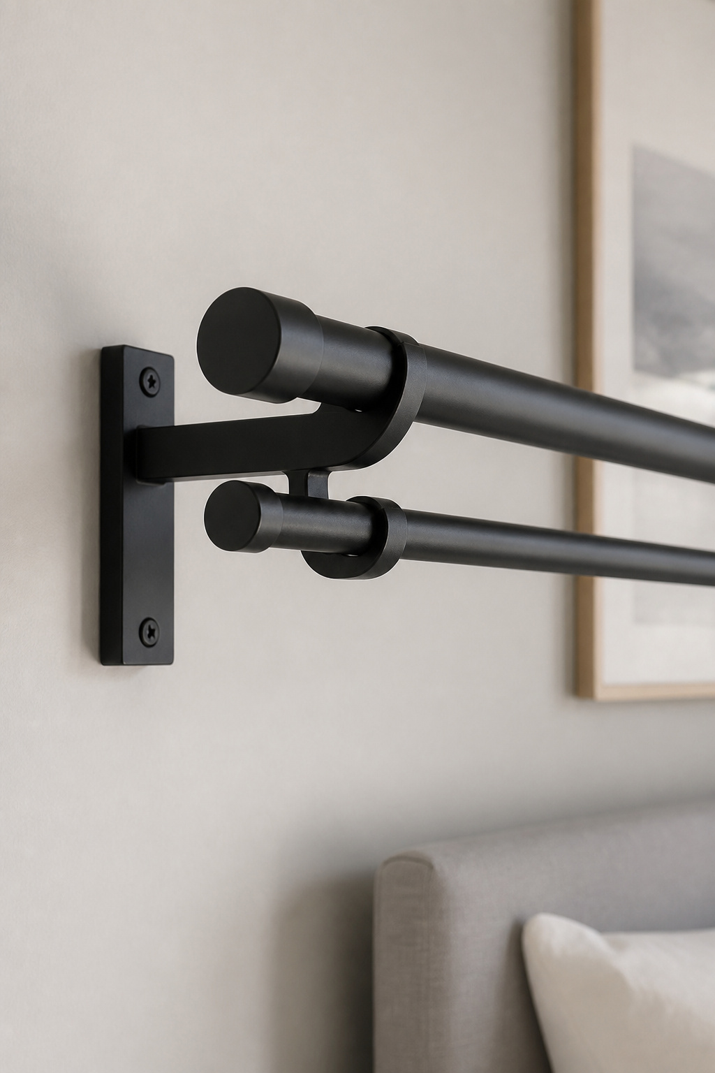 Double curtain rod bracket on a bedroom wall holding an inner and outer rod for layered curtains
