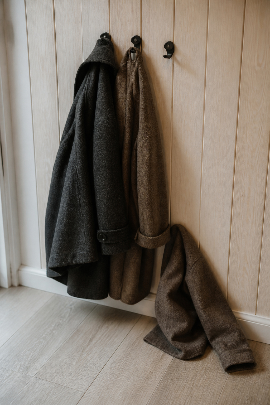 Coats crowded and slipping off closely spaced entryway hooks