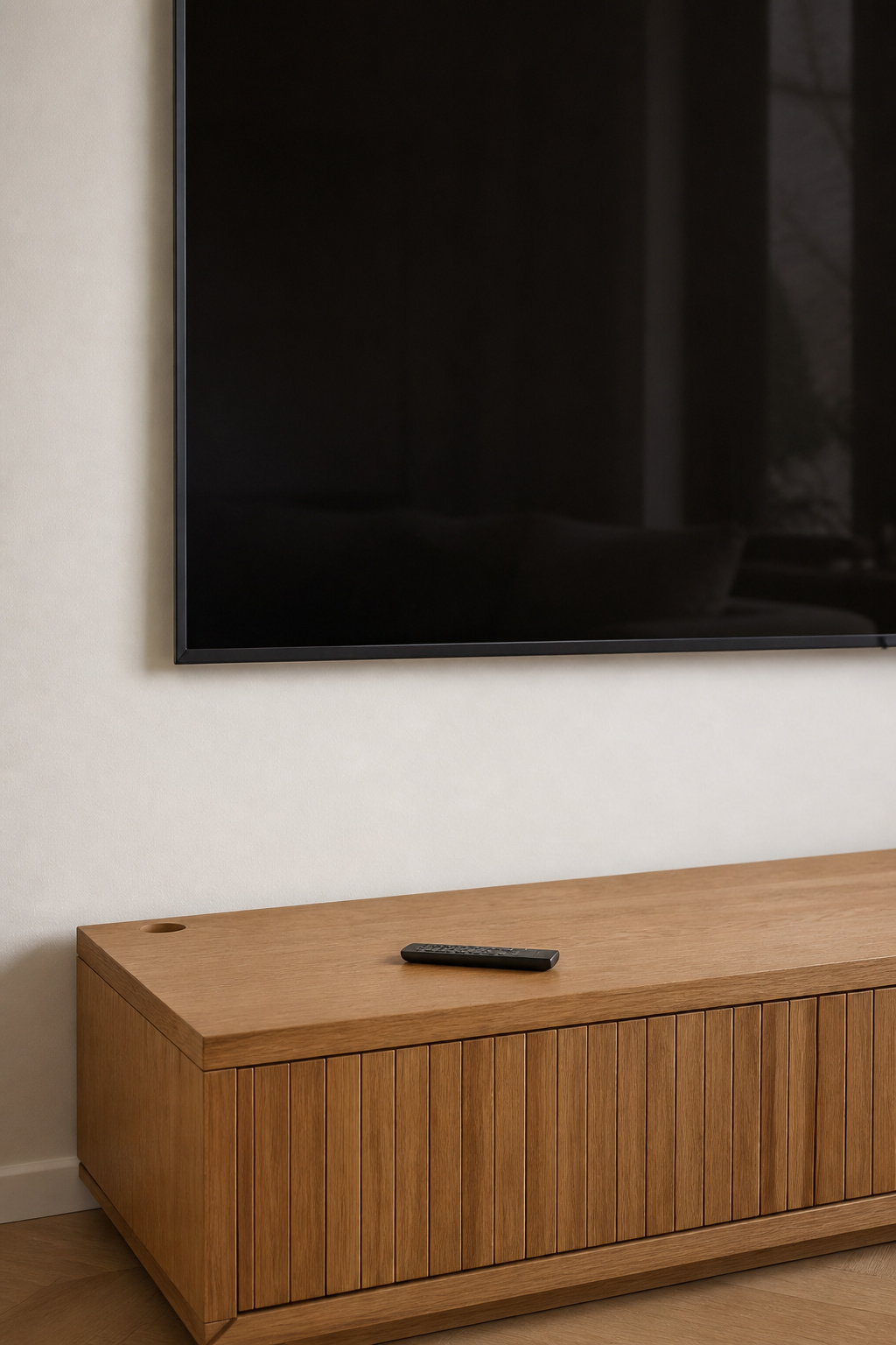Minimalist TV wall with zero visible cables between screen and console, in-wall routing behind warm-white plaster