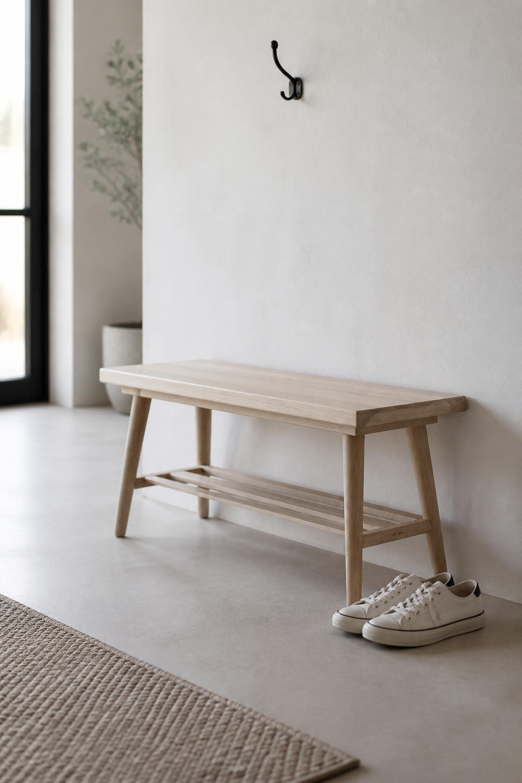 Pale ash narrow entryway bench with tapered legs and lower rail set against a white wall, with 36 inches of open floor in front