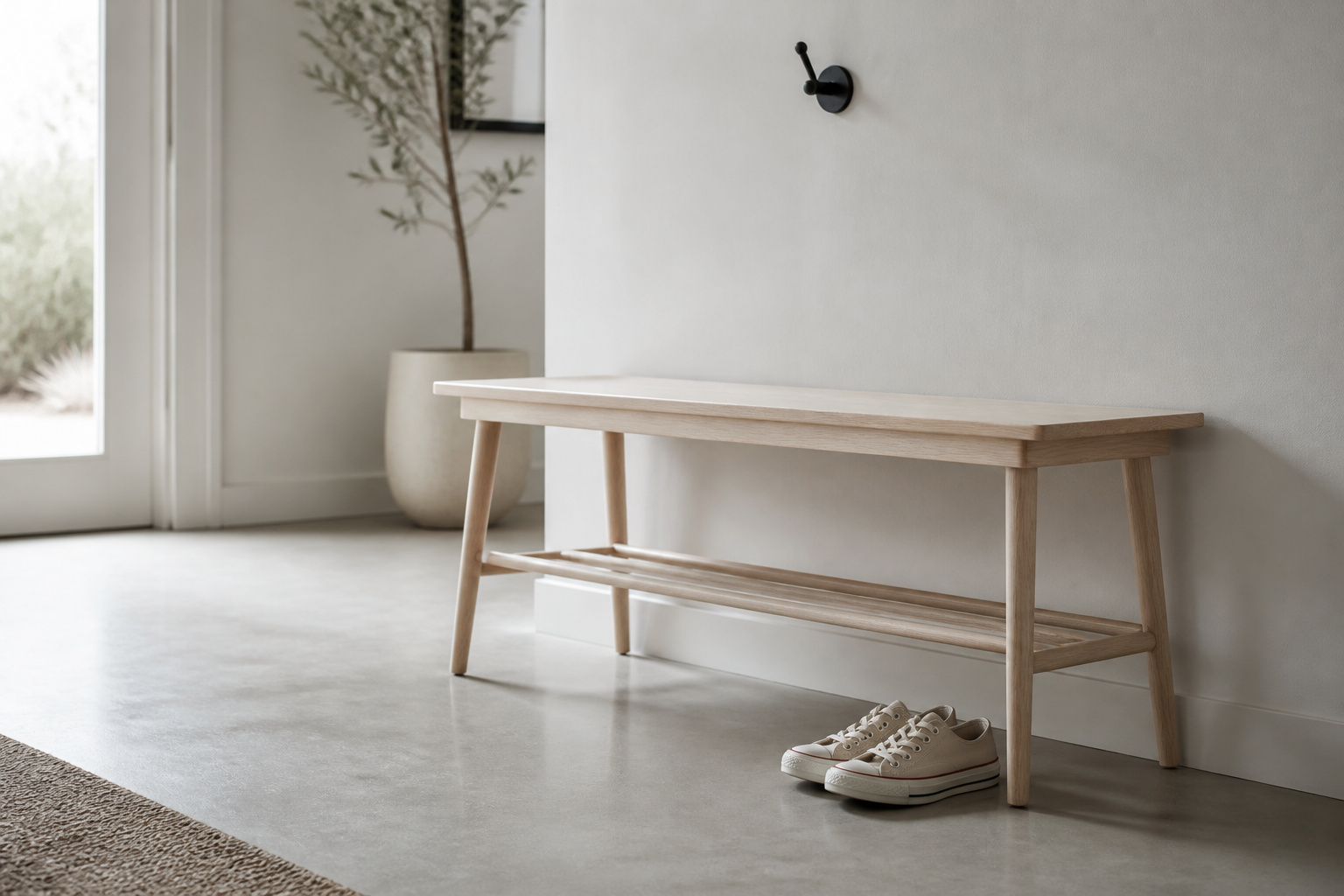 Pale ash narrow entryway bench with tapered legs and lower rail set against a white wall, with 36 inches of open floor in front