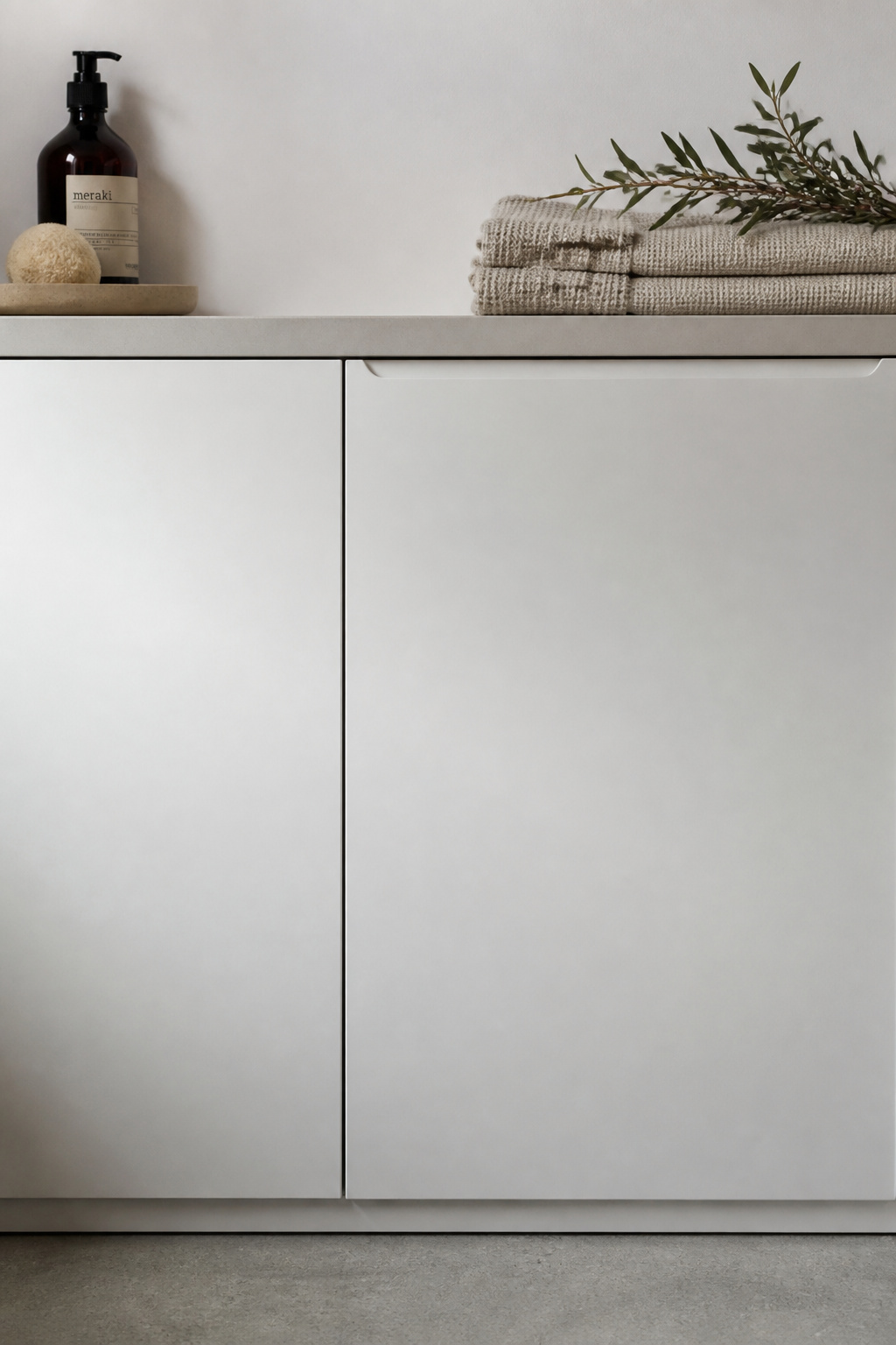 Flat-panel white handleless cabinet doors with finger-pull groove in a Scandinavian laundry room, no visible hardware