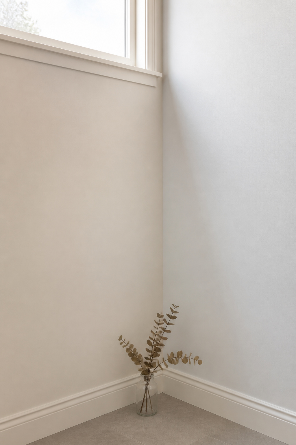 Laundry room corner showing warm off-white versus cool white wall paint under north-facing daylight, revealing the undertone difference