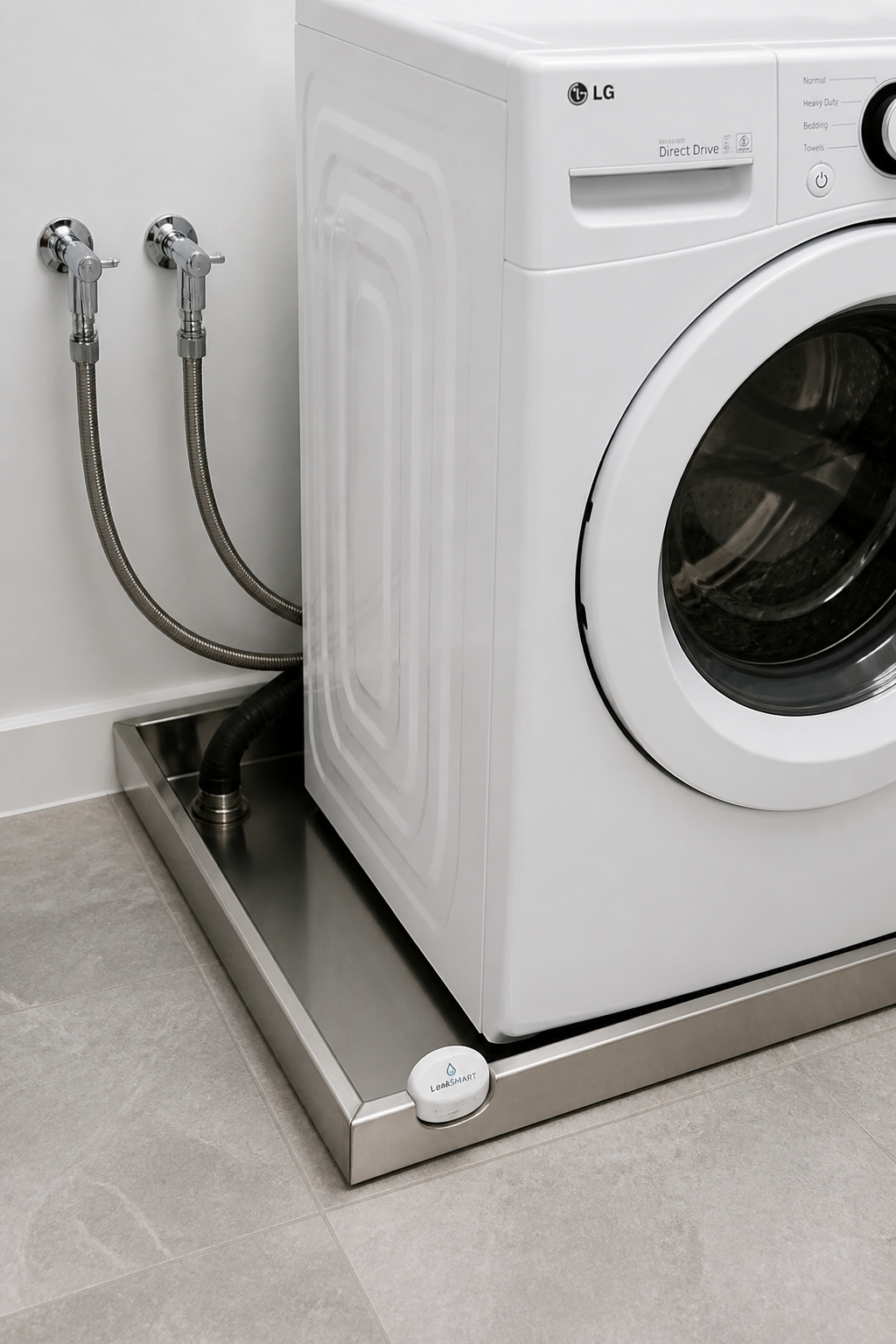 Front-loading washing machine in stainless drain pan with plumbed drain hose, steel-braided supply hoses, ball valves and leak sensor