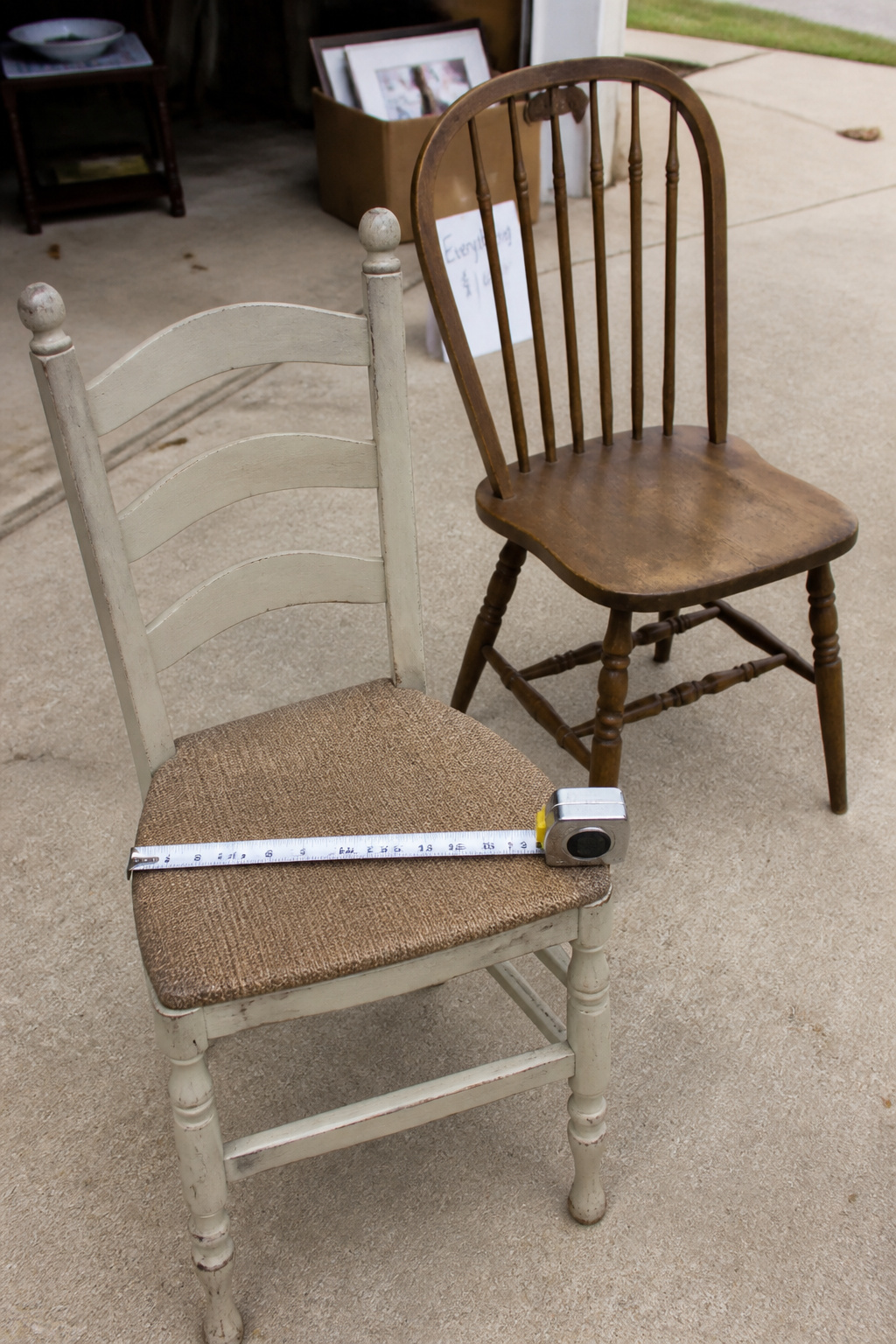 Measuring seat height on a mismatched dining chair at an estate sale using a tape measure