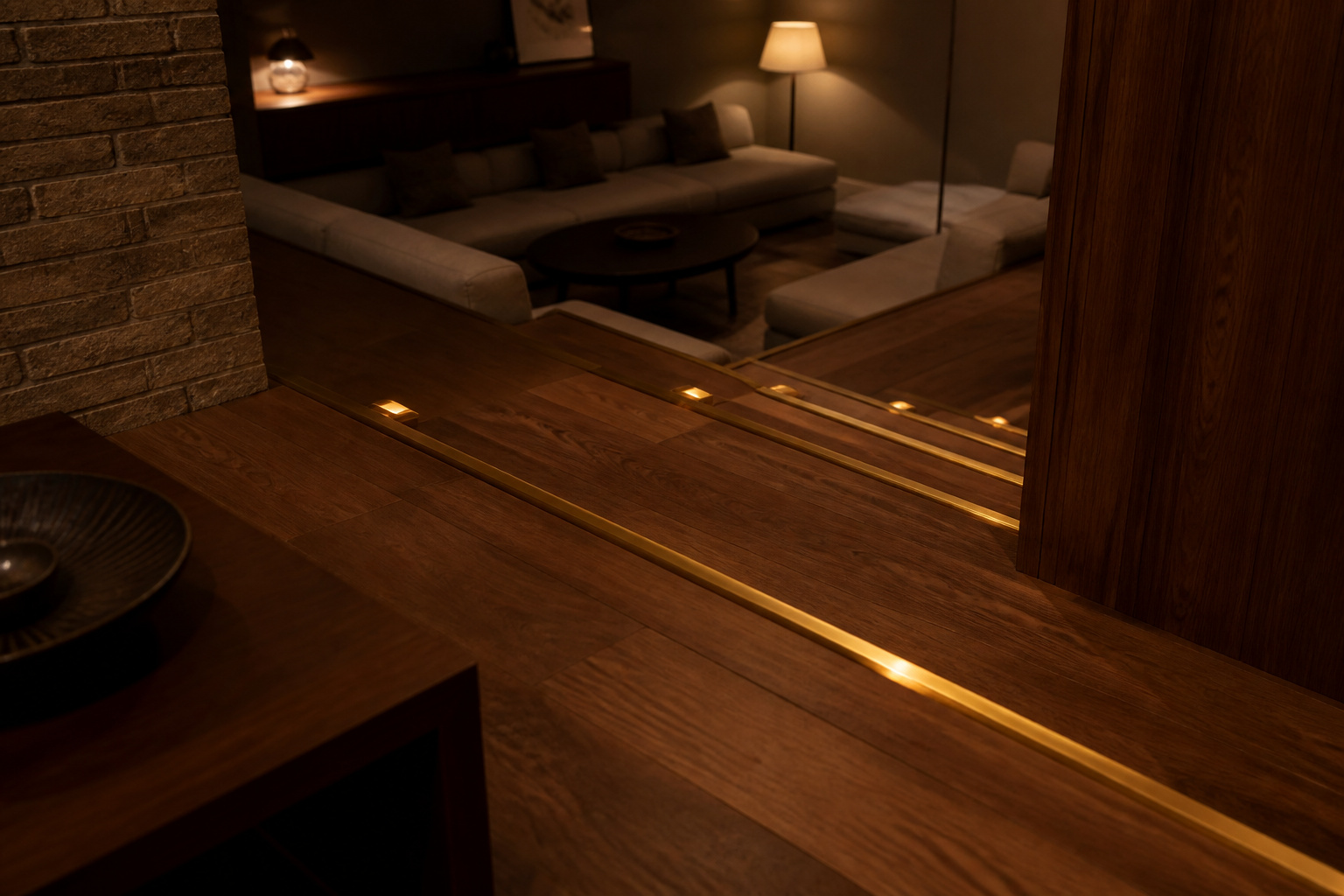 Sunken living room at night with brass step lights glowing along the edge of the lower seating pit